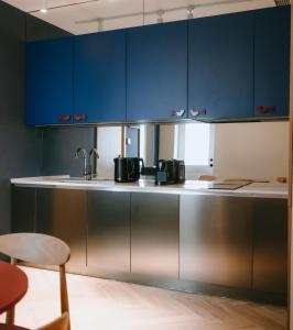 a kitchen with blue cabinets and a sink at Meidan Heritage Suites Tbilisi in Tbilisi City +46 photos