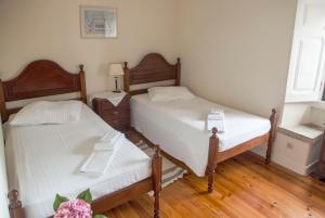 two beds in a small room with wooden floors at Quinta Santo António in Sintra