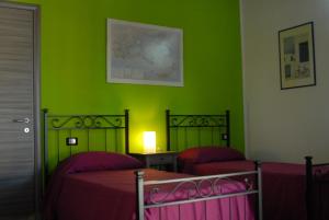 two beds in a room with green walls at Hotel Samarcanda in Civitavecchia