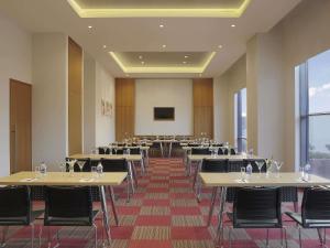 a conference room with tables and chairs and a screen at Ibis Chennai OMR - An Accor Brand in Chennai +114 photos