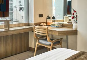 a wooden desk with a chair in front of a window at Tran Long Hotel By Urban B in Ho Chi Minh City