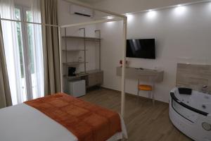 a bedroom with a tub and a bed and a sink at Gegè Relais in San Corrado di Fuori +23 photos