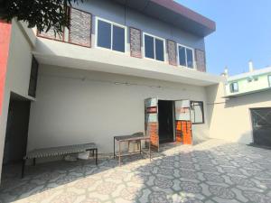 a building with a bench in front of it at Vivek Hotel in Banbāsa