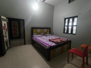 a bedroom with a bed and a chair in it at Vivek Hotel in Banbāsa