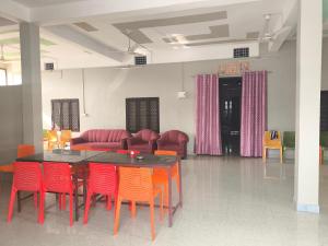 a room with a table and chairs and a couch at Vivek Hotel in Banbāsa