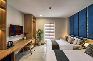 a hotel room with two beds and a desk at Tran Long Hotel By Urban B in Ho Chi Minh City