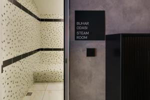 a bathroom with a door with a sign on it at Grande Arte Hotel in Eskisehir