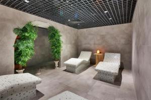 a room with two chairs and a table and plants at Grande Arte Hotel in Eskisehir
