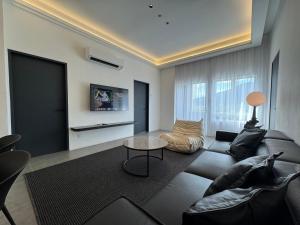 a living room with a couch and a table at Langkawi Simfoni Beliza Apartment with Sky Pool by Zervin in Kuah