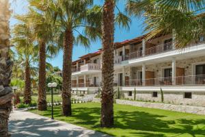 a building with palm trees in front of it at Byzantio Resort in Parga