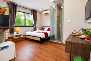 a bedroom with a bed and a glass shower at Ostro Hotel in Phnom Penh