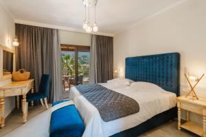 a bedroom with a large bed with a blue headboard at Byzantio Resort in Parga +51 photos