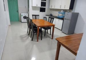 a kitchen with a wooden table and chairs in a kitchen at MSM DIAMOND guesthouse 1 in Male City