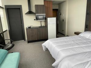 a bedroom with a white bed and a refrigerator at Hotel Centro Braseros in Burgos
