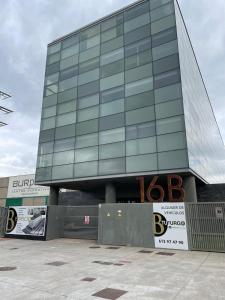 a glass building with a sign in front of it at Hotel Centro Braseros in Burgos