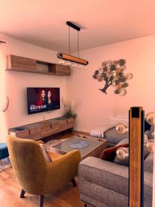 a living room with a couch and a tv at Bjelašnica Slope View in Bjelašnica