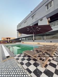 a pool with chairs and umbrellas next to a building at PARK CITY HOTEL & Resort in Gangāyapalle +37 photos