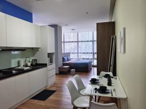 a kitchen and living room with a table and chairs at Bangsar Trade Centre By WeCare in Kuala Lumpur