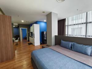 a bedroom with a blue bed and a living room at Bangsar Trade Centre By WeCare in Kuala Lumpur