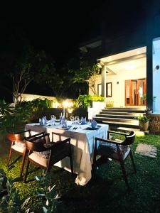 a table with a white tablecloth and chairs in a yard at Villa Sathkara in Tangalle +77 photos