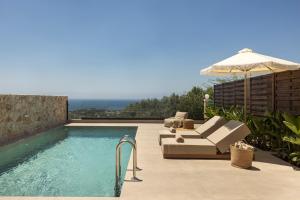 a swimming pool with an umbrella and a couch and an umbrella at Don Gerassimo in Argostoli