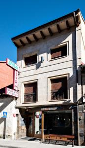 a building with a bench in front of it at Hotel El Roble in Cervera de Pisuerga