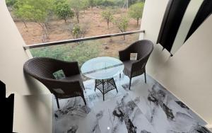 a glass table and chairs on a balcony with a view at PARK CITY HOTEL & Resort in Gangāyapalle