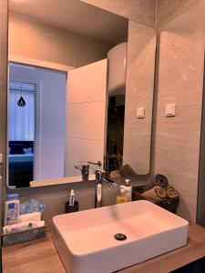 a bathroom with a white sink and a mirror at Bjelašnica Slope View in Bjelašnica +5 photos
