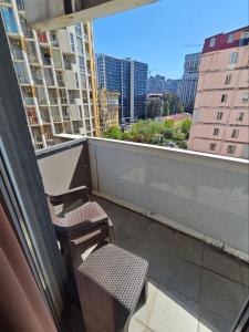 a balcony with two chairs and a view of a city at Dorbi Recidense in Itʼkhvisi