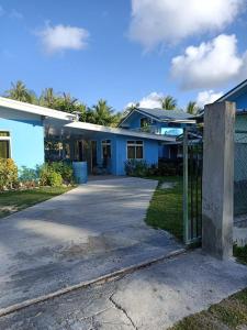 a house with a fence in front of a driveway at Terai vahine lodge in Rangiroa +7 photos
