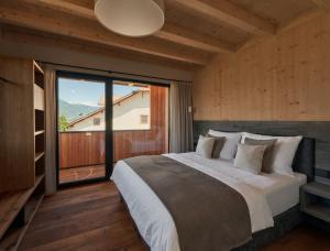 a bedroom with a large bed and a large window at Anima-Suites adults only in Terlano