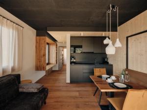 a kitchen and living room with a table and a couch at Anima-Suites adults only in Terlano +18 photos
