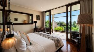 a bedroom with a bed and a large window at Private beach Oceanfront 3bd Villa in Cemagi +44 photos