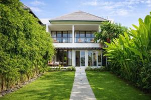 a house with a pathway leading to the front yard at Private beach Oceanfront 3bd Villa in Cemagi
