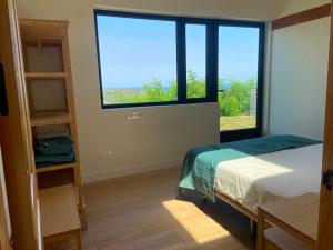 a bedroom with a bed and a large window at Hotel Villa Itsaso in Lekeitio