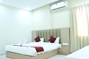 a bedroom with a bed with white sheets and red pillows at Hotel B R Residency in Bikaner +26 photos