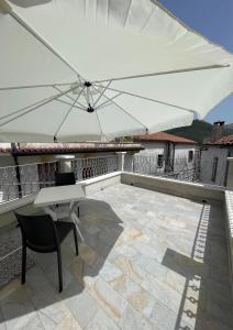 een witte parasol op een balkon met een tafel en stoelen bij Dimora AVE in Aieta +4 foto's
