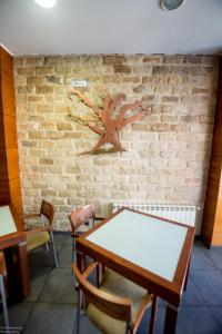 a dining room with a wooden table and a brick wall at Hotel El Roble in Cervera de Pisuerga