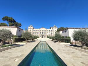 a view of a building with a pool in front of it at Le Charmant-Terrasse-Vue et accès Piscine -15 in Laredorte