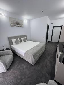 ein Schlafzimmer mit einem großen Bett und einer Couch in der Unterkunft Hotel Daly in Ploieşti + 55 Fotos
