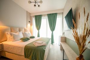 a bedroom with a large bed with green curtains at Blue Boat Aparthotel in Mamaia Sat/Năvodari +220 photos