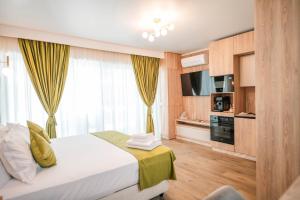 a hotel room with a bed and a television at Blue Boat Aparthotel in Mamaia Sat/Năvodari