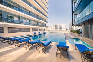 a pool on the roof of a building with blue chairs at Blue Boat Aparthotel in Mamaia Sat/Năvodari