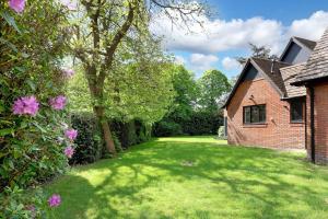 a yard with a brick house and a tree at Wings Annexe in Beaconsfield