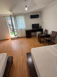 a room with two beds and a desk and a piano at Emilia Hotel Batumi Old Town in Batumi