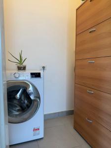 a washer and dryer in a room with a closet at I Due Gelsi appartamento Green in Monte San Giusto +9 photos
