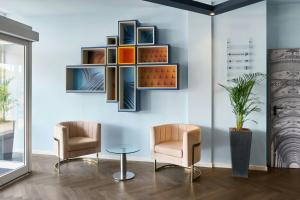 two chairs and a table in a room at Four Points Flex by Sheraton Bologna Airport in Bologna