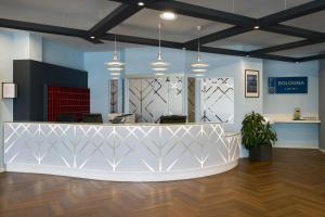 an office lobby with a reception counter and potted plants at Four Points Flex by Sheraton Bologna Airport in Bologna