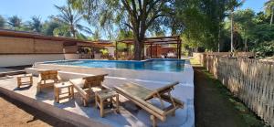 a swimming pool with a picnic table and a bench at The Tree Poolbar&Resort in Gili Islands