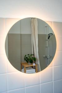 a bathroom with a round mirror on a wall at Seeblick Apartment Meersburg in Meersburg +16 photos
